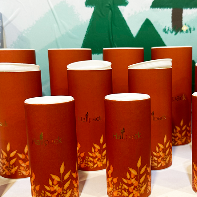 La mano de Hallpack hace el empaquetado redondo del cilindro de papel de la caja del tubo del casquillo plástico de envío biodegradable